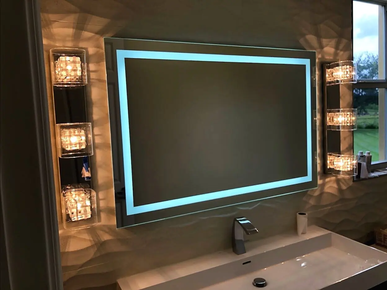 Custom illuminated rectangular LED mirror above a vanity