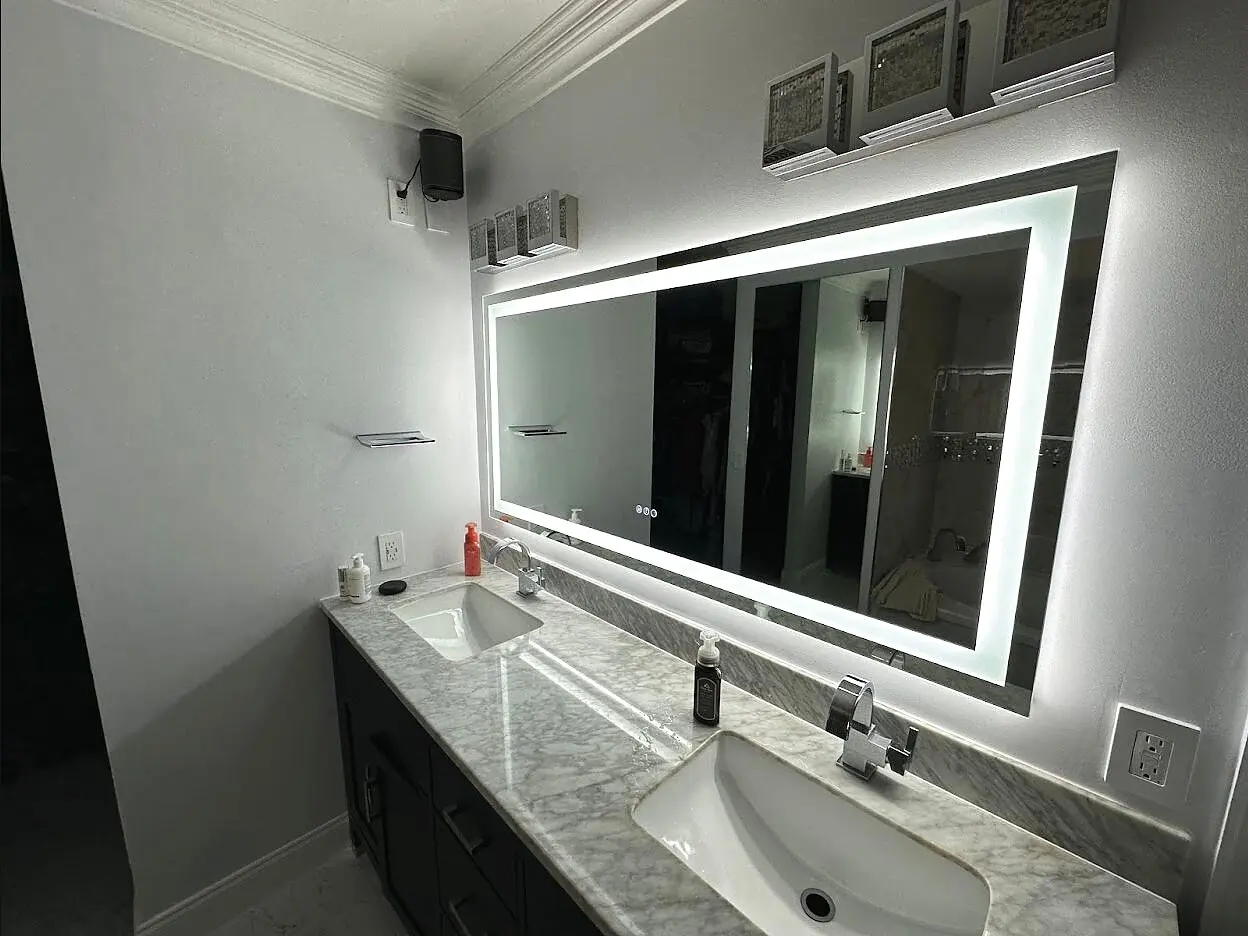 Wide illuminated mirror above a double vanity
