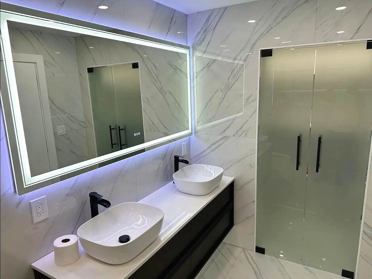LED mirror paired with a custom glass shower installation