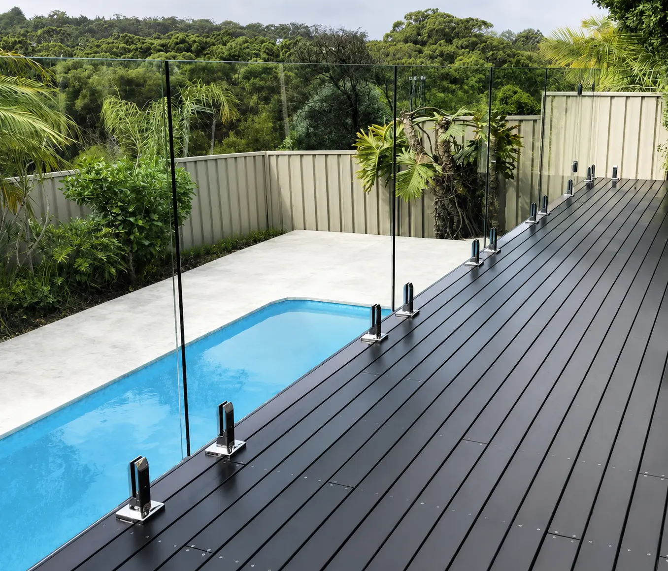 Clear glass railing beside a residential swimming pool