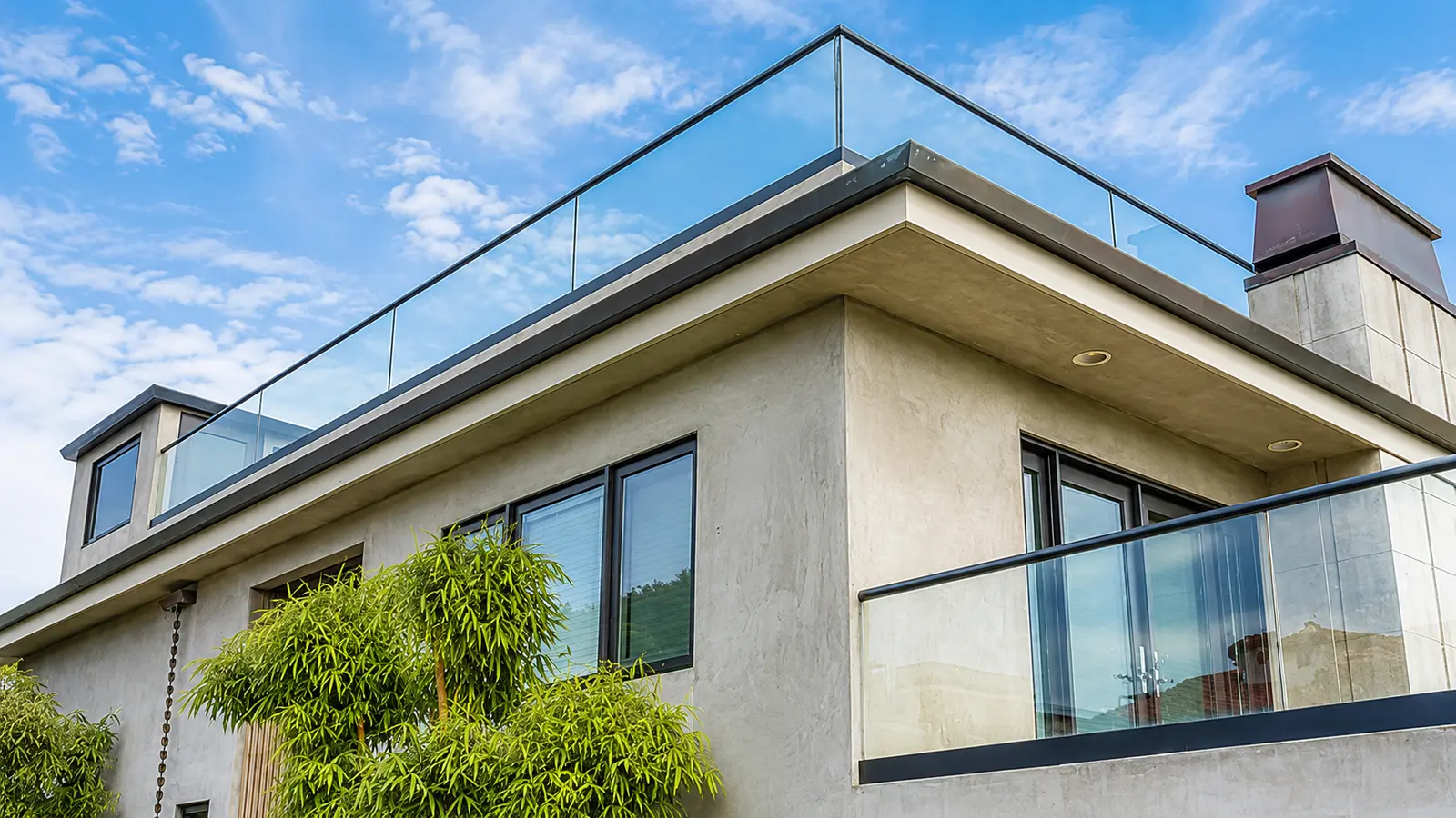 Frameless glass railing around a modern rooftop terrace