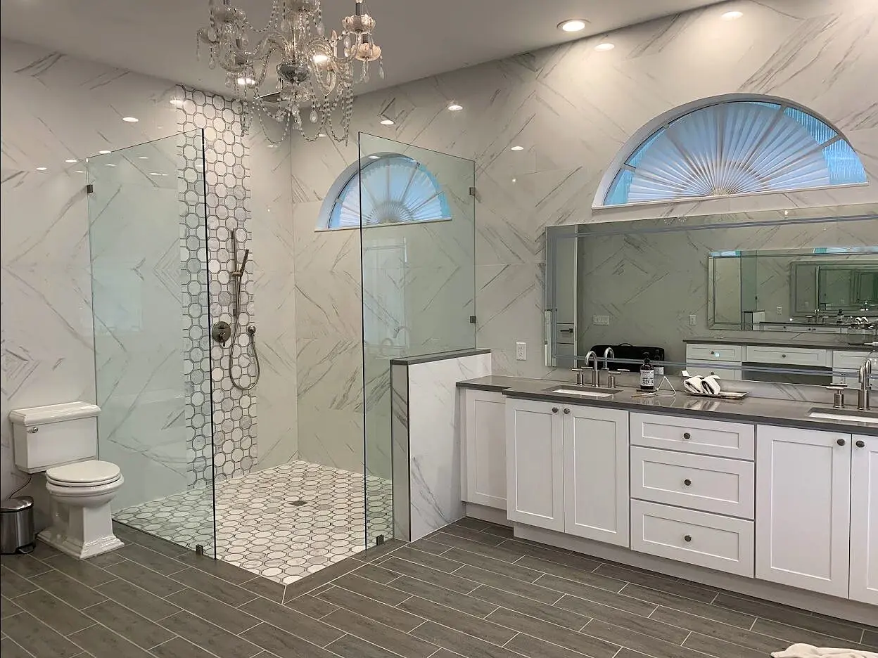 Frameless shower enclosure in a modern dark-and-white bathroom