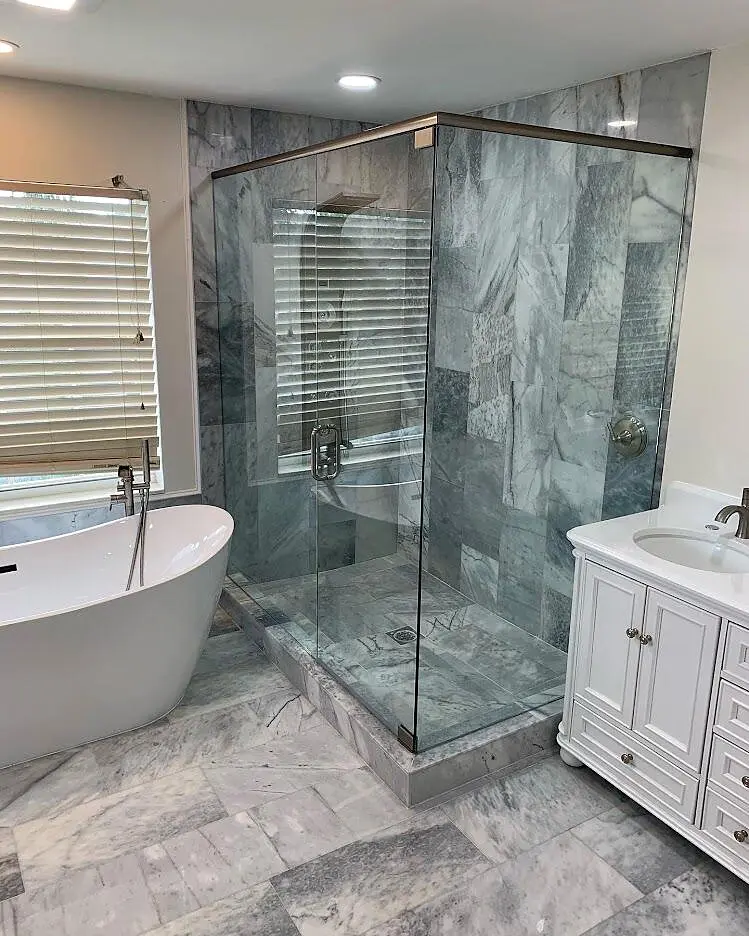 Custom frameless shower beside a freestanding bathtub